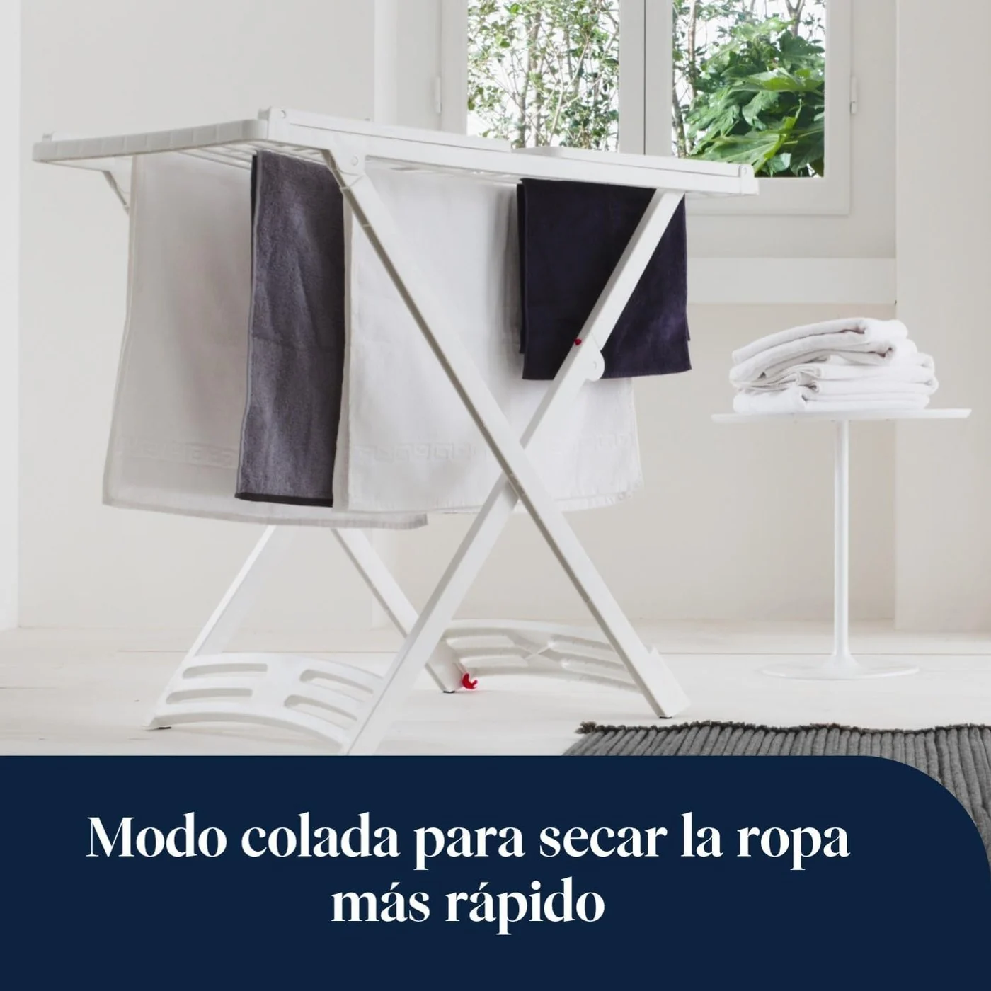 Ropa secándose en un tendedero con el De'Longhi DNS65 al lado